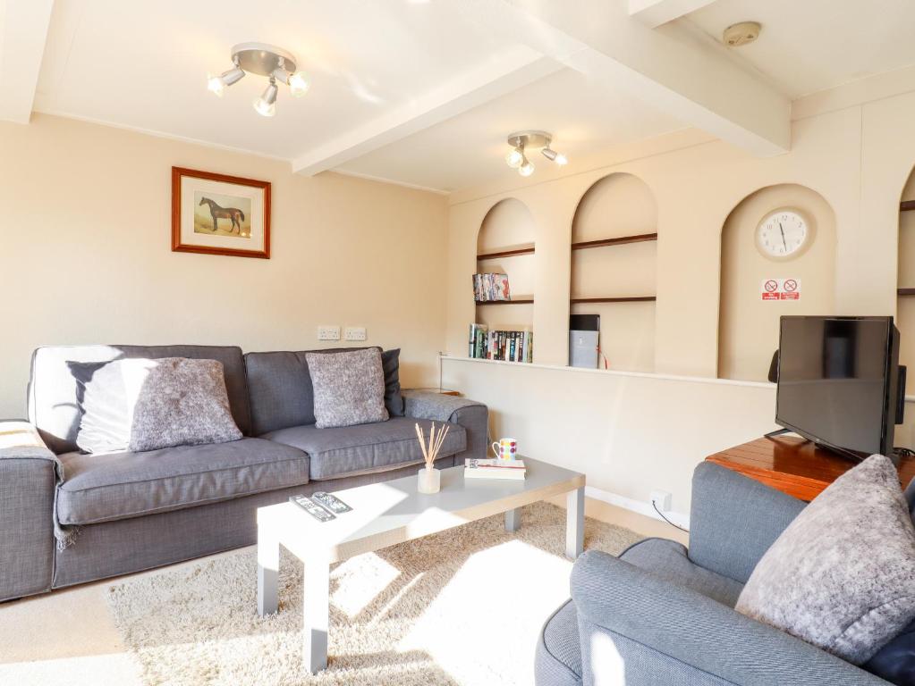 a living room with a couch and a table at Vine Cottage in Halstead