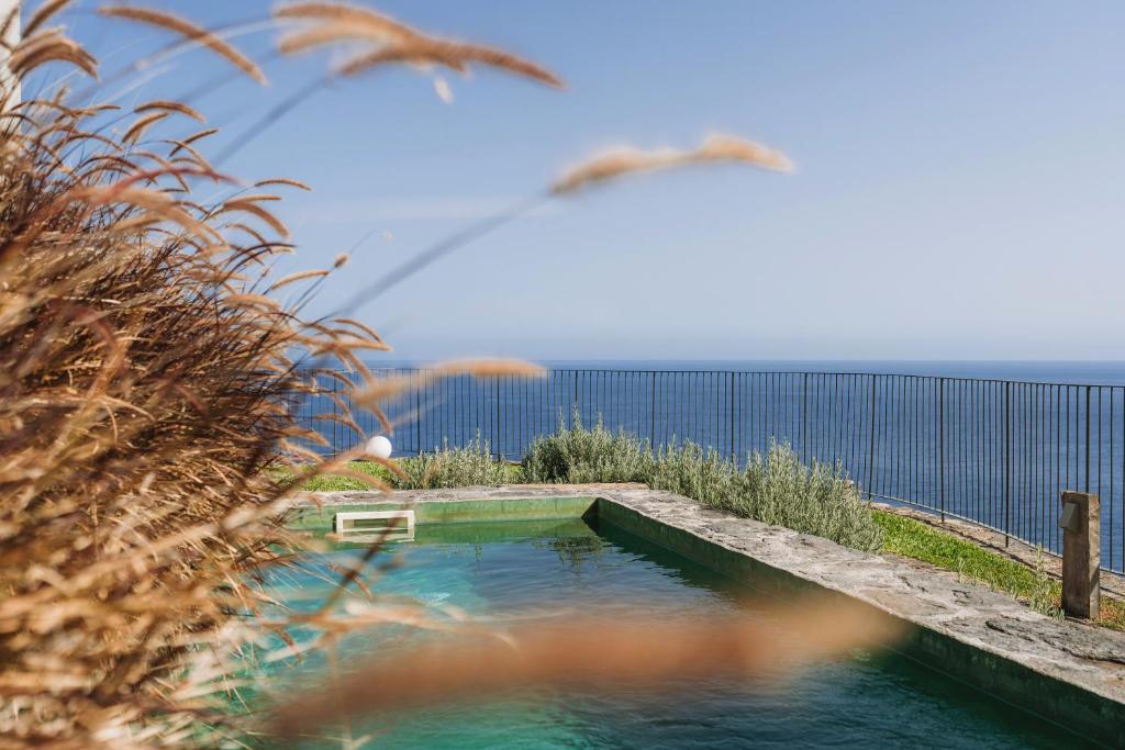 a swimming pool with the ocean in the background at Socalco Nature Calheta in Calheta