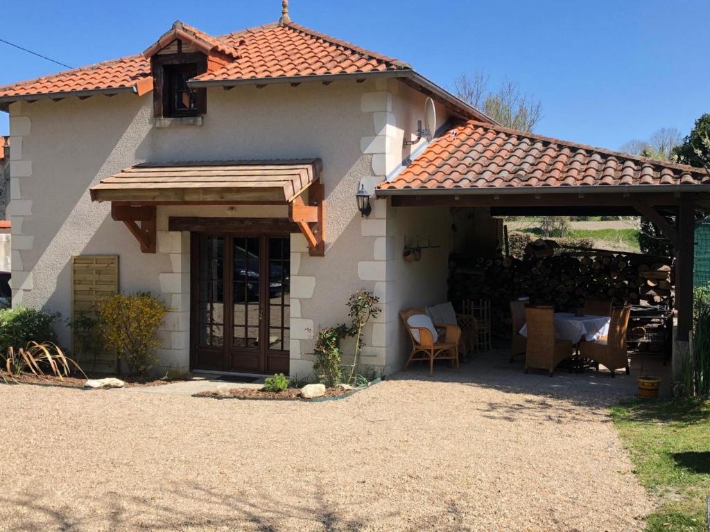 a small house with a porch and a patio at Le relais de la motte in Thuré