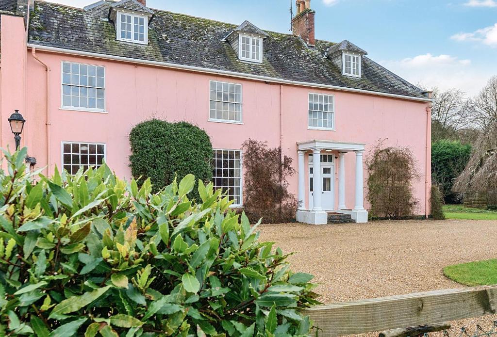 a pink house with a driveway in front of it at Old Ford House in Blandford Forum