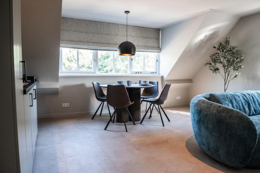 a living room with a blue couch and a table at Sfeervol appartement voor 2 personen De Jonge Blomme in Kamperland