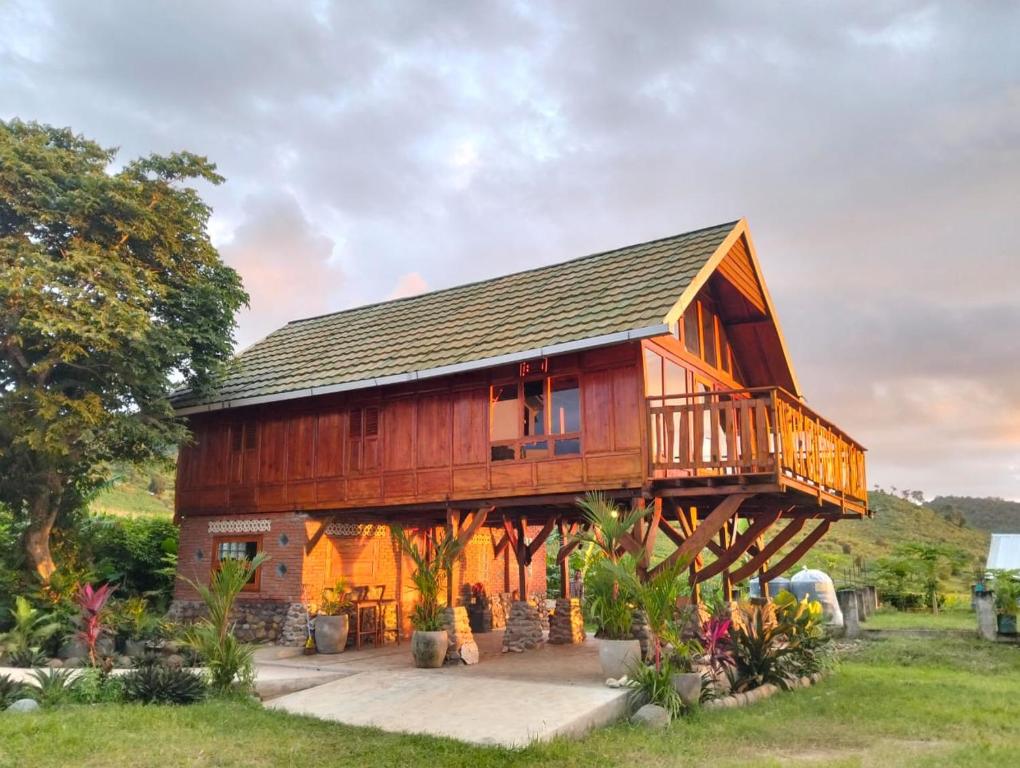 a wooden house with a gambrel roof at Lakey Views Sumbawa in Huu