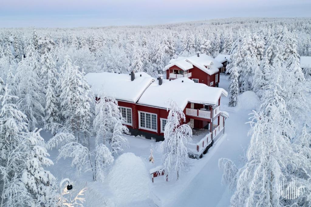 a house covered in snow in a forest of trees at Levi Kätkänlinna 20A by Holiday in Lapland in Kittilä