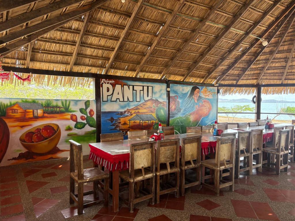 a restaurant with a table and chairs and a mural at Refugio Pantu in Cabo de la Vela