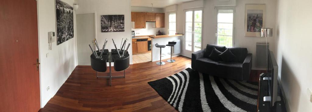 a living room with a couch and a table at Appartement near Disneyland in Serris