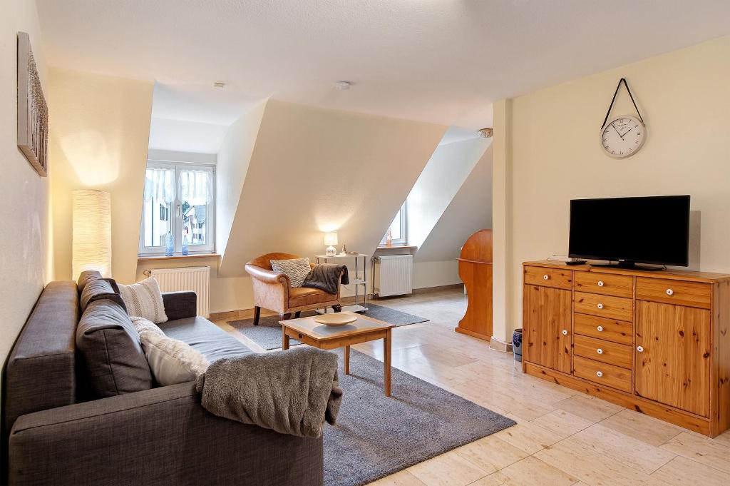 a living room with a couch and a flat screen tv at Ferienwohnung F Bolanz 1 in Auggen