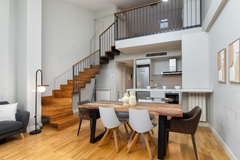 a kitchen and dining room with a wooden table and chairs at Flateli Nord in Girona