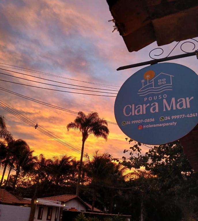 a sign for a cala mar restaurant with a sunset in the background at Pouso Clara Mar in Paraty