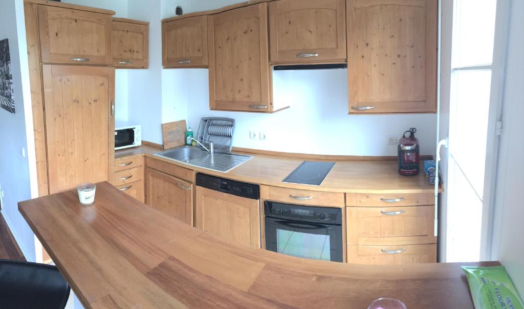 a kitchen with wooden cabinets and a wooden counter top at Appartement near Disneyland in Serris