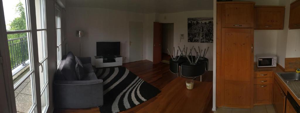 a living room with a couch and a television at Appartement near Disneyland in Serris