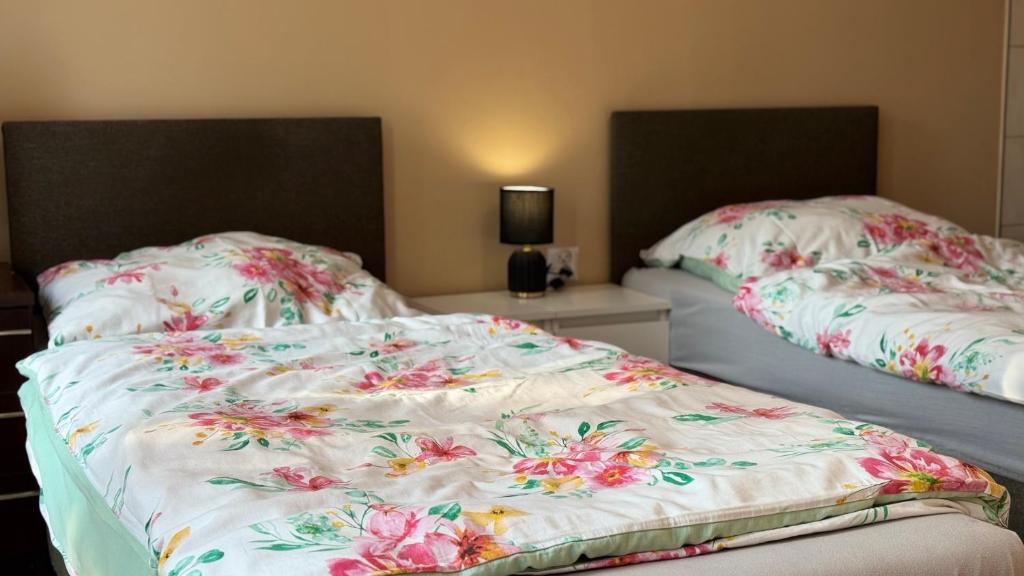 a bedroom with two beds with flowers on them at Noclegi Witoszyn - Akacjowa 2 in Witoszyn Dolny