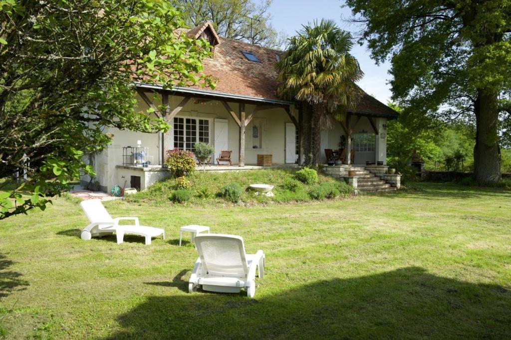 a house with two lounge chairs in the yard at Les forts in Leigné-les-Bois