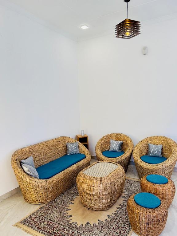 a living room with four wicker chairs with blue seats at Mananjay Natures Retreat in Jāmb
