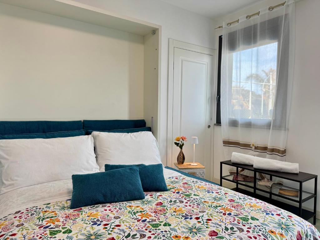 a bedroom with a large bed with a colorful blanket at Aurora View Resort - Boutique Suites in Mascali