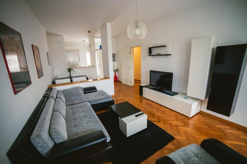 sala de estar con sofá y TV de pantalla plana en Viktorija Apartment, en Belgrado