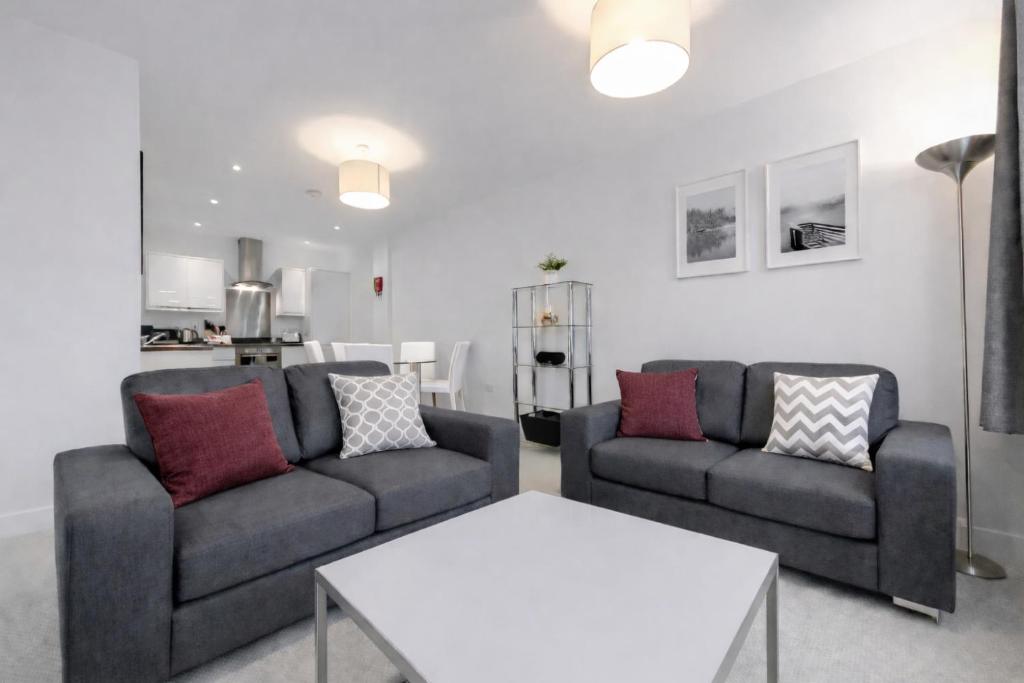 a living room with two couches and a table at Roomspace Serviced Apartments - Nouvelle House in Sutton