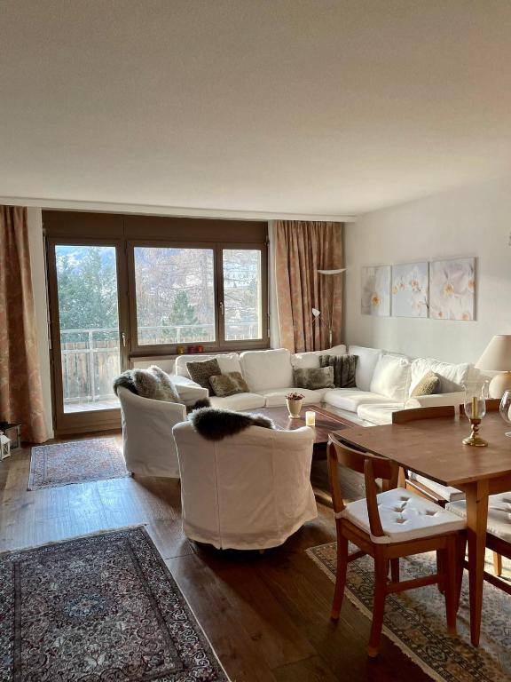 a living room with a white couch and a table at Small bijoux Disentiserhof in Disentis