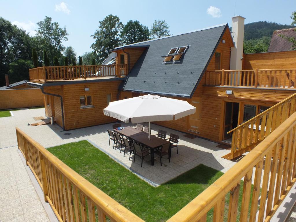 a patio with a table and an umbrella at Chaty pod Sokolím Hřbetem in Česká Ves