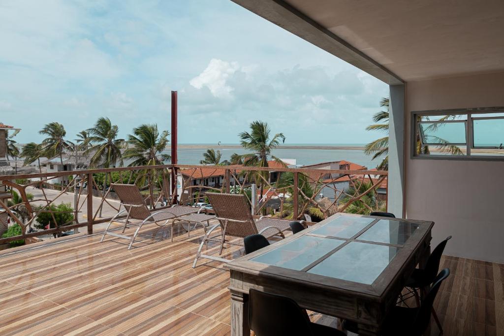 a balcony with a table and chairs and the ocean at Kicoh - Kite Community House in Itarema