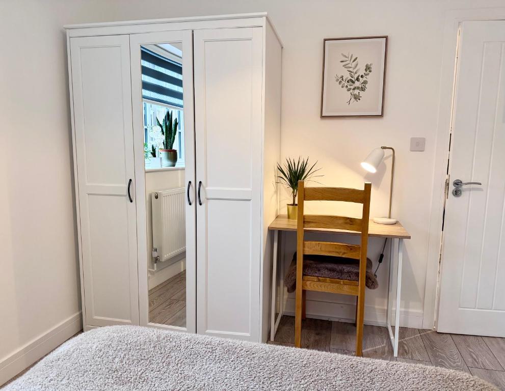 a bedroom with a door and a desk with a chair at Spacious En-suite Private Double Bedroom in Oxford