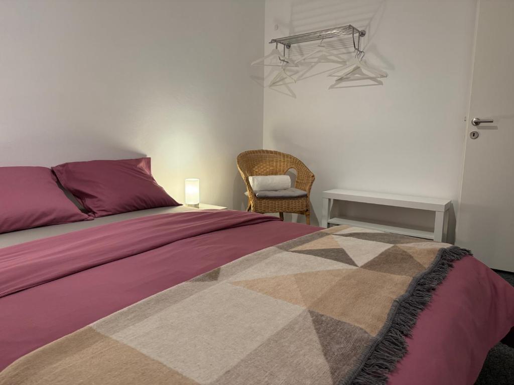 a bedroom with a bed and a chair at Ferienwohnung Biendi in Trimmis