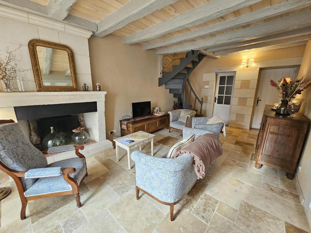 a living room with two chairs and a fireplace at Le logis in Mairé