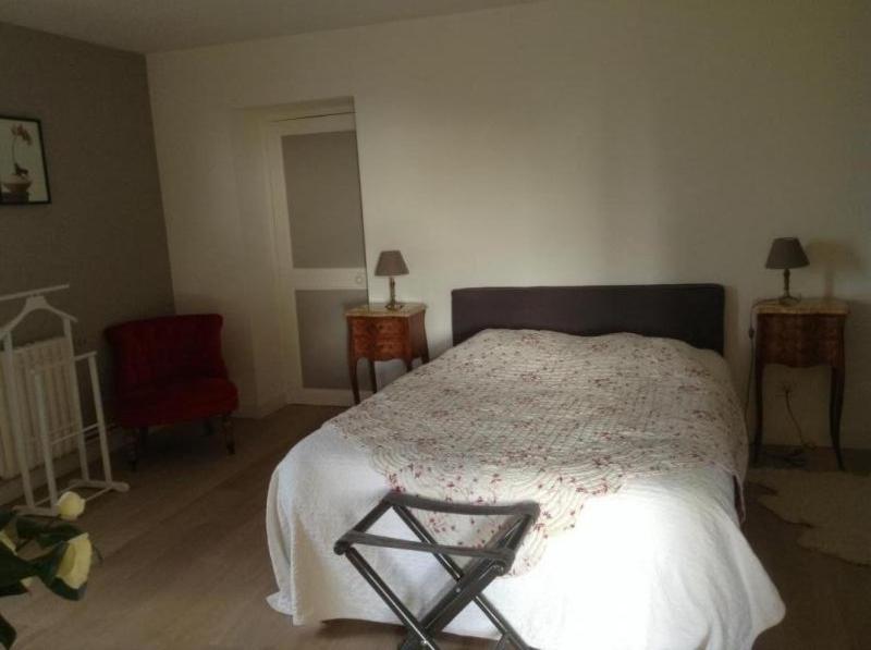 a bedroom with a bed and a red chair at La pocterie in Vouneuil-sur-Vienne