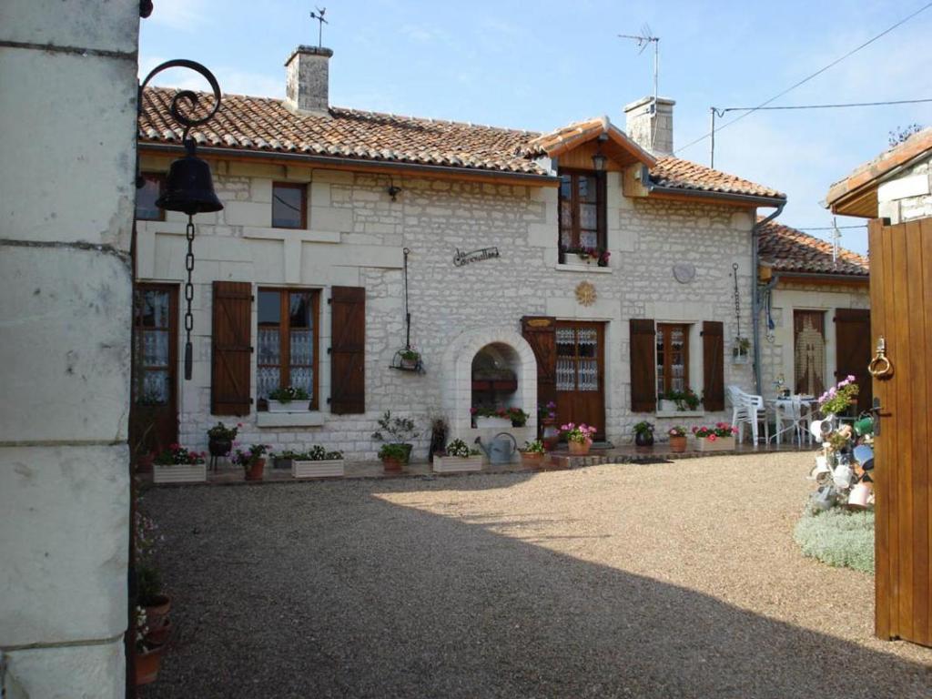 a white brick house with a driveway in front of it at La cornouillère in Champau