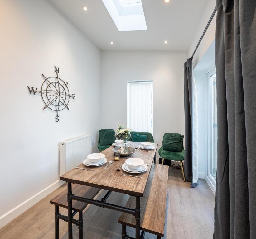 a dining room with a wooden table and green chairs at Runswick Road in Bristol