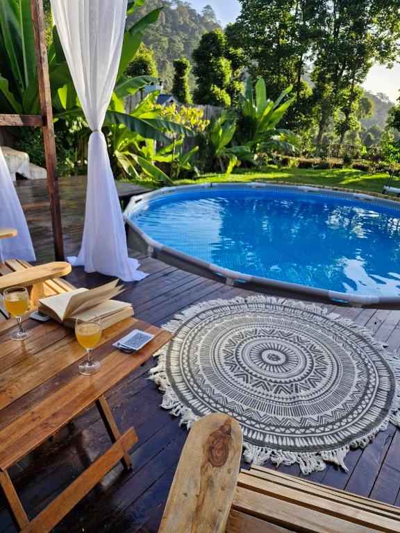 a swimming pool with a table and glasses of wine at Kitanda Msituni in Meru