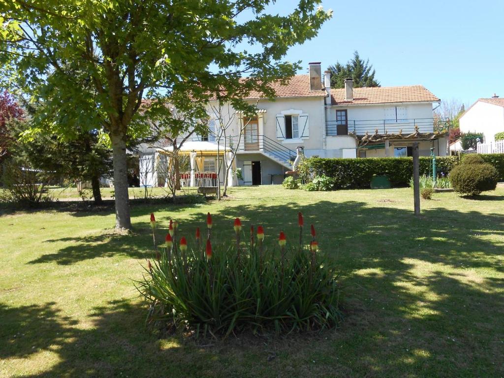 a house with a bunch of red tulips in a yard at La forge de louis in Saint-Macoux