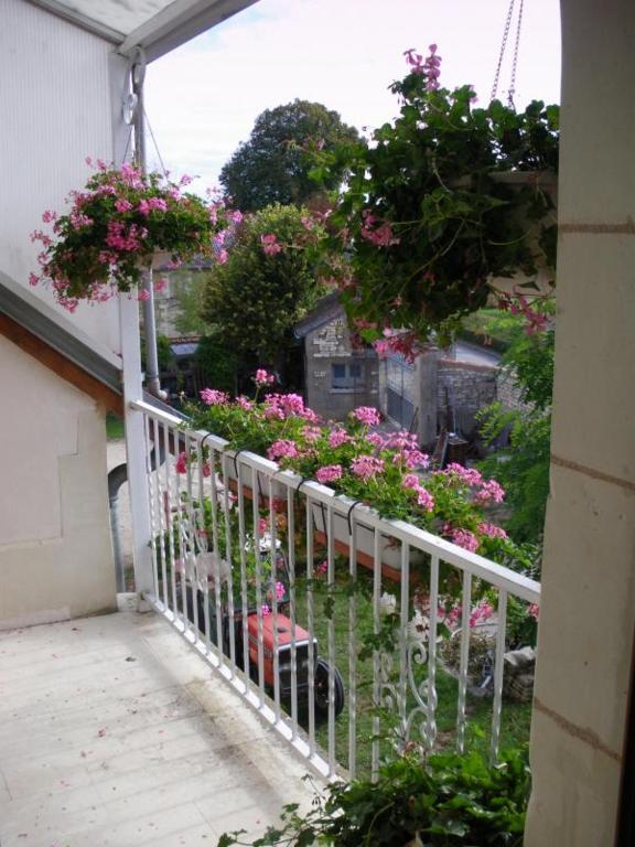 a porch with pink flowers and a white fence at Le grenier d'alice in Thurageau