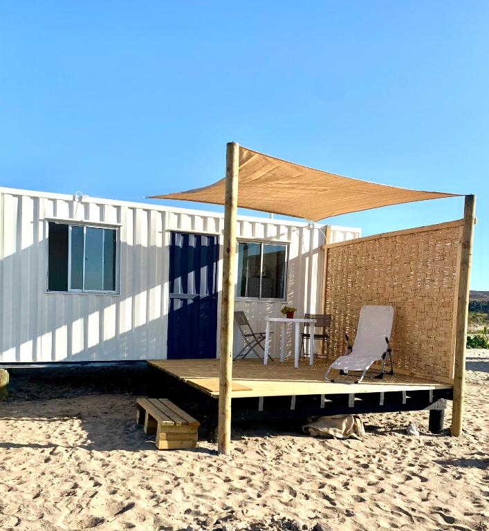a house on the beach with a table and a chair at Cabañas ecológicas Tongoy in Tongoy