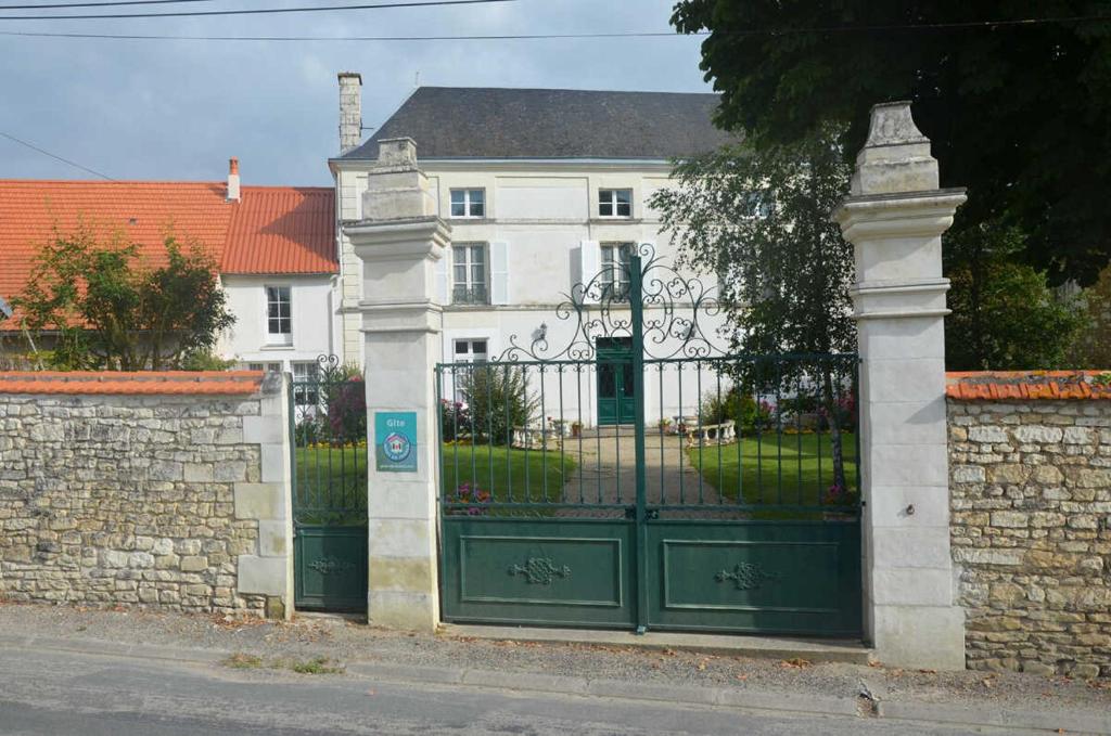 a green gate in front of a white house at La maisons des tilleuls in Thurageau
