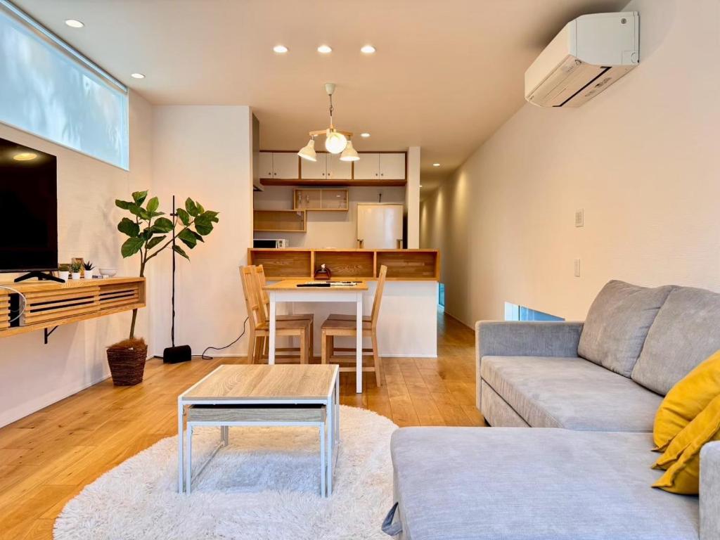 a living room with a couch and a table at ura アルコバレーノ奉還町 in Okayama