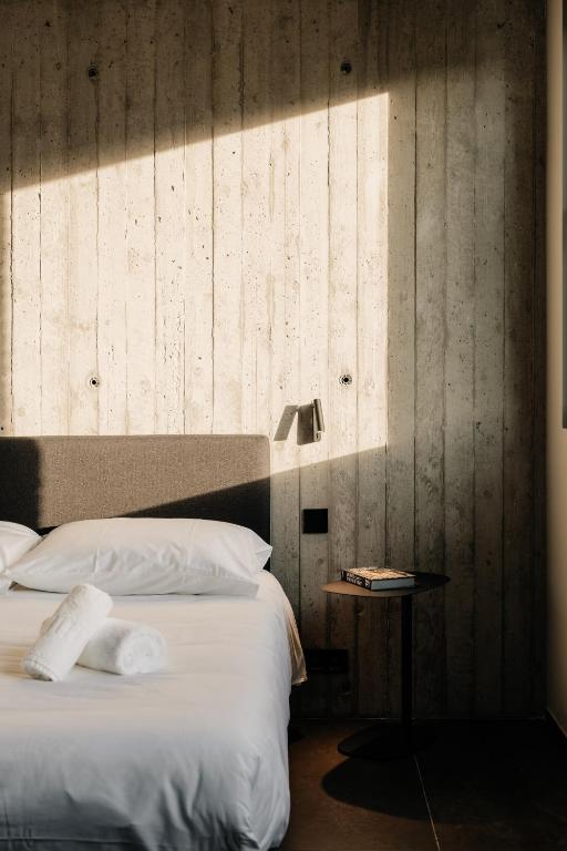 a bedroom with a bed and a side table at Coliving - Bord de Meuse - L'échappée Mosane in Oupeye