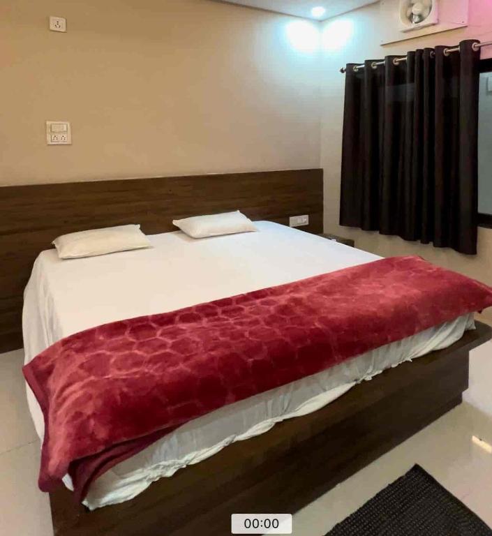 a bedroom with a large bed with a red blanket at Hotel shiv shakti yatri niwas in Maihar