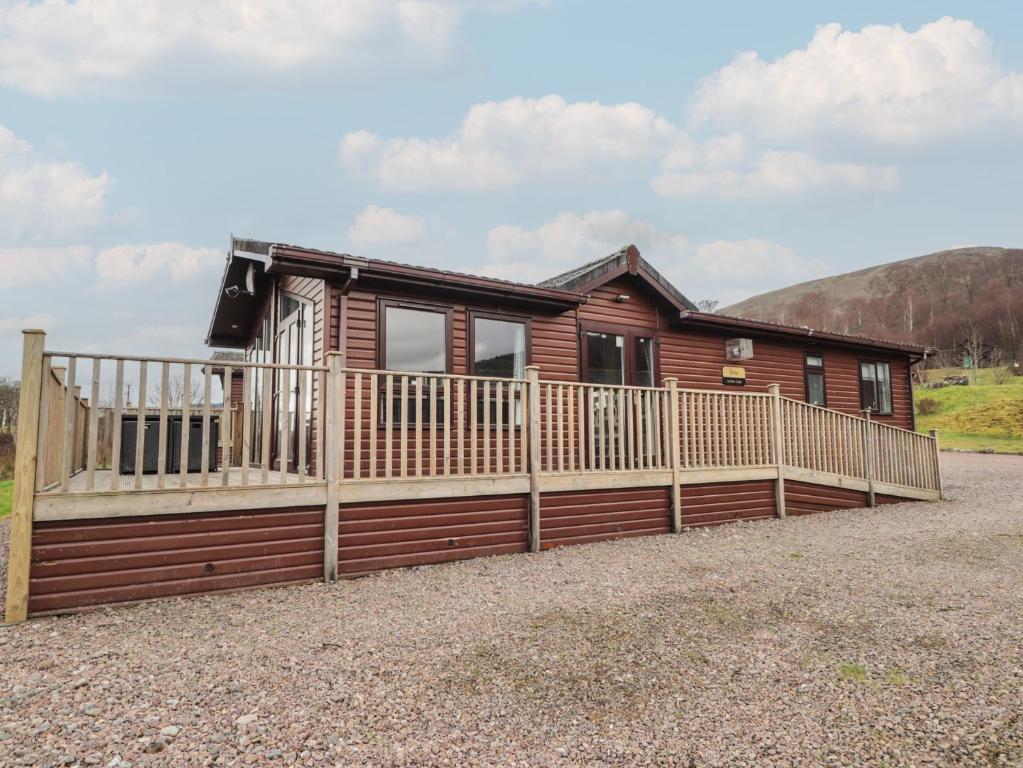 a house with a wooden fence in front of it at Iona Lodge in Fort William