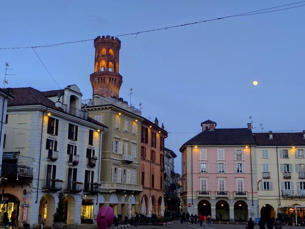 a city street with buildings with a clock tower at Loft Piazza Cavour Vercelli in Vercelli