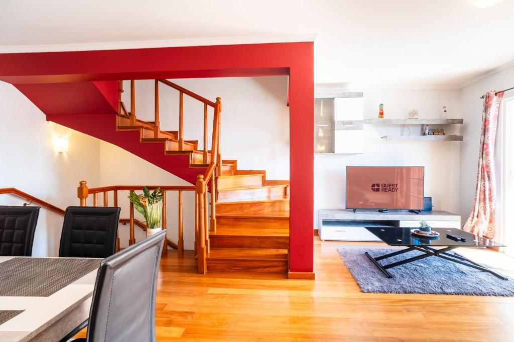 a living room with a red staircase and a dining room at GuestReady - Alluring island retreat in Santa Cruz