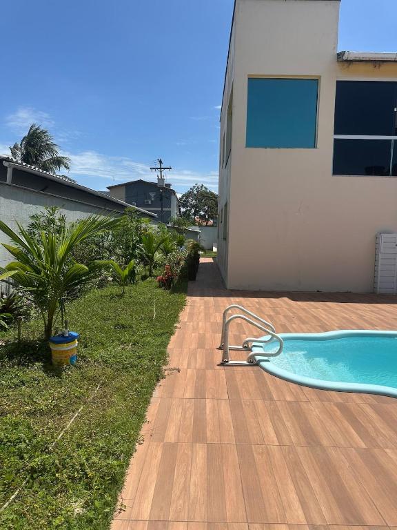 a swimming pool in a yard next to a house at Casa de Praia 6 quartos e 4 suítes! in Valença