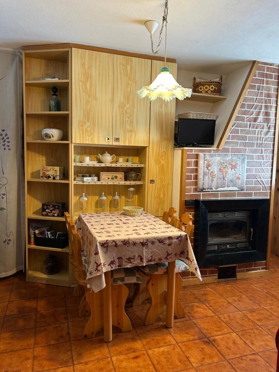 a dining room with a table and a fireplace at Casa Chigi in Valdidentro