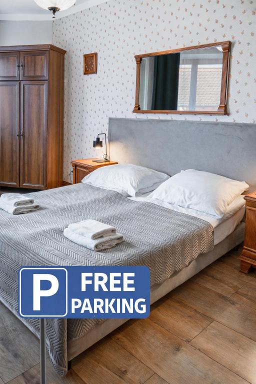 a bed in a bedroom with a sign free parking at Royal Gdansk in Gdańsk
