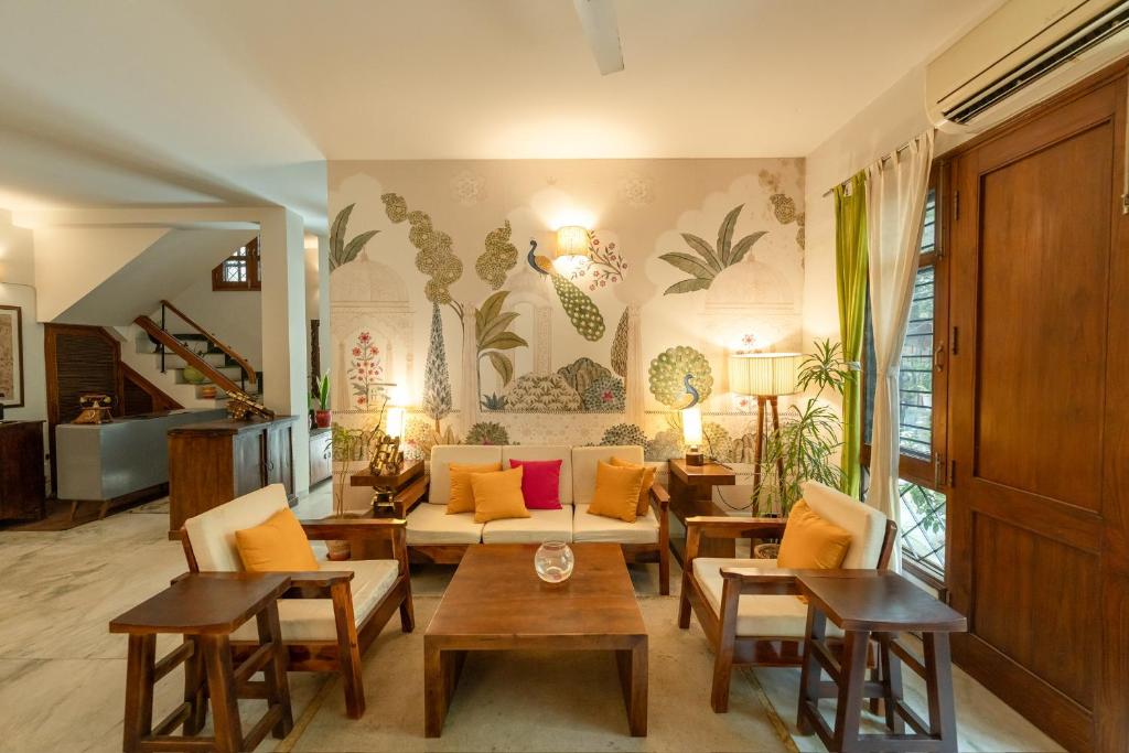 a living room with a couch and tables at Art KOTHI Gurgaon in Gurgaon