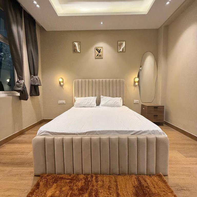 a bedroom with a large bed with a white bedspread at SAC HOUSE Sector 41 in Gurgaon