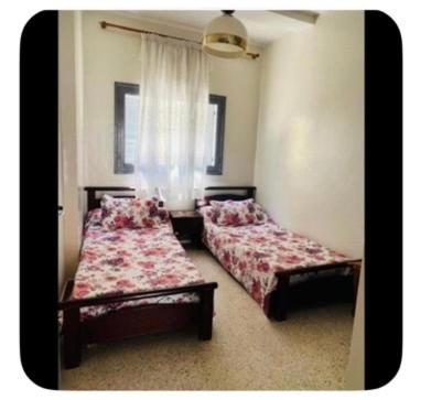 a bedroom with two beds and a window at Dar Khnata in Temara