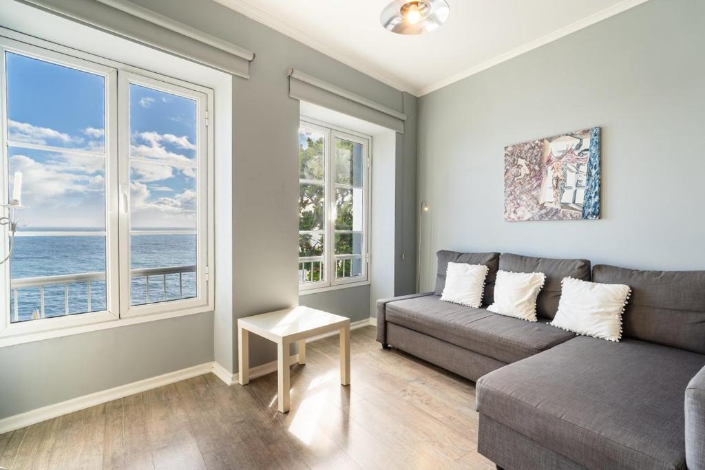 a living room with a couch and two windows at Barreirinha II Near Old Town With Nice Ocean Views in Funchal