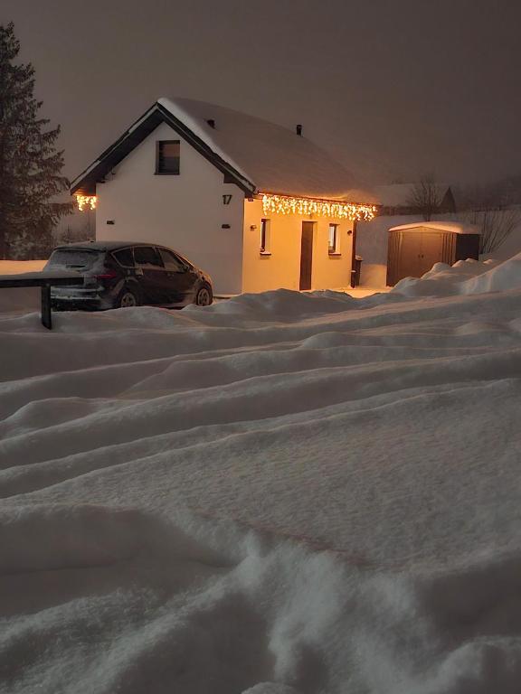 a car parked in a parking lot covered in snow at Domek na Ogrodowej in Tylicz