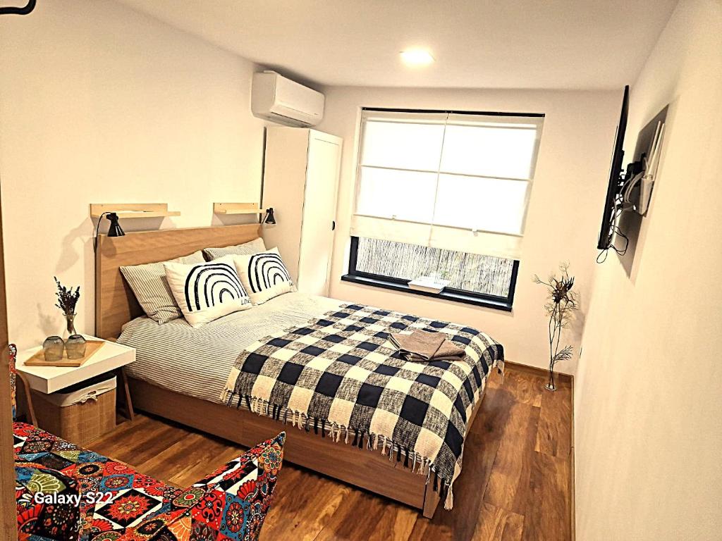 a small bedroom with a bed and a window at Georgia Tiny House - Hiperbara Livezeni Mures in Livezeni