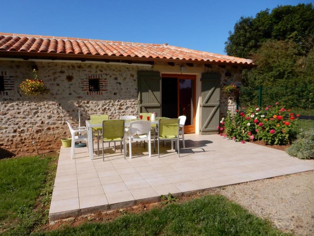 a patio with chairs and a table in front of a house at Gîte de la vacherie in Port de Salles